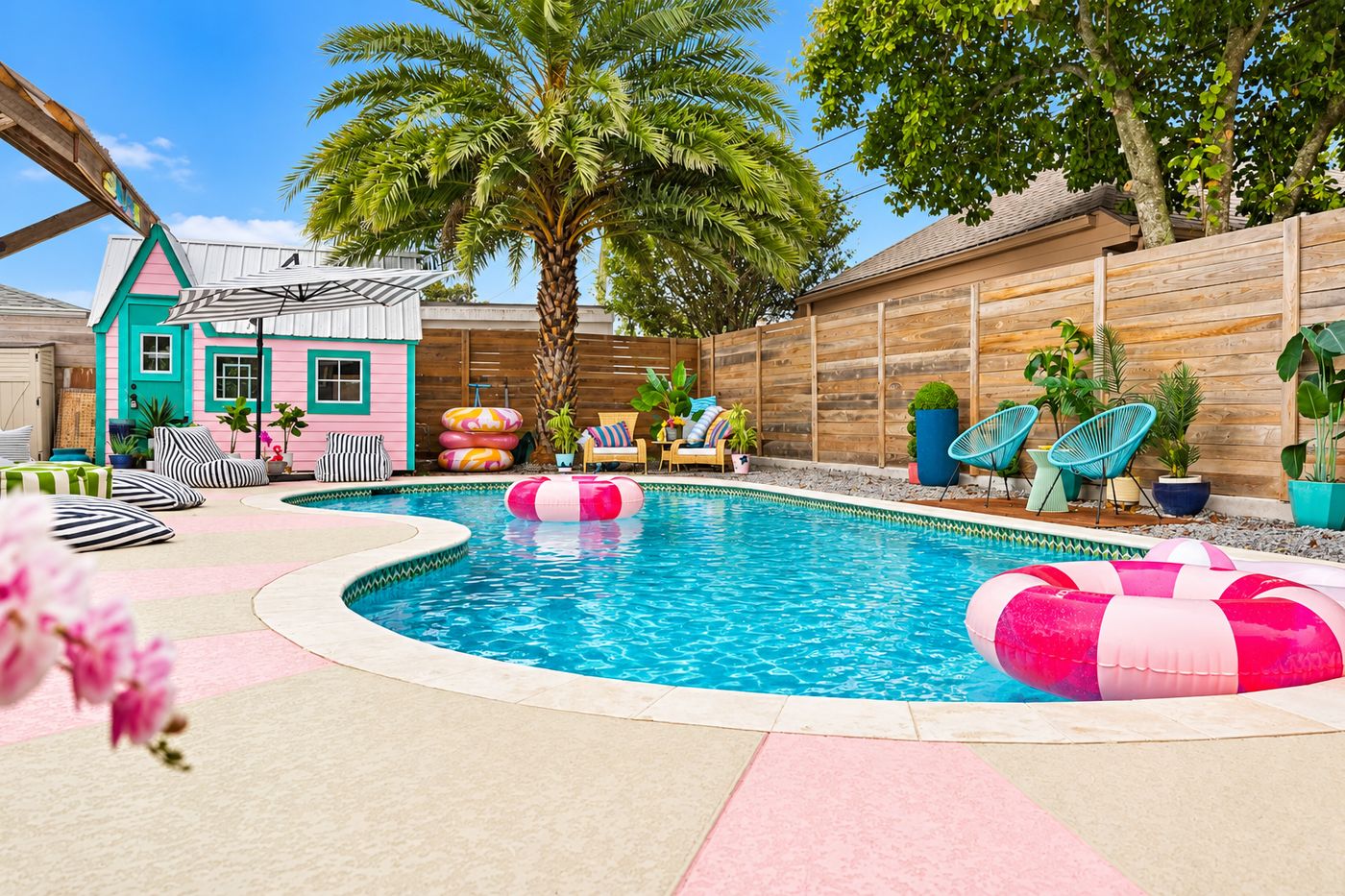 Freeform pool with a pink and sand coated deck